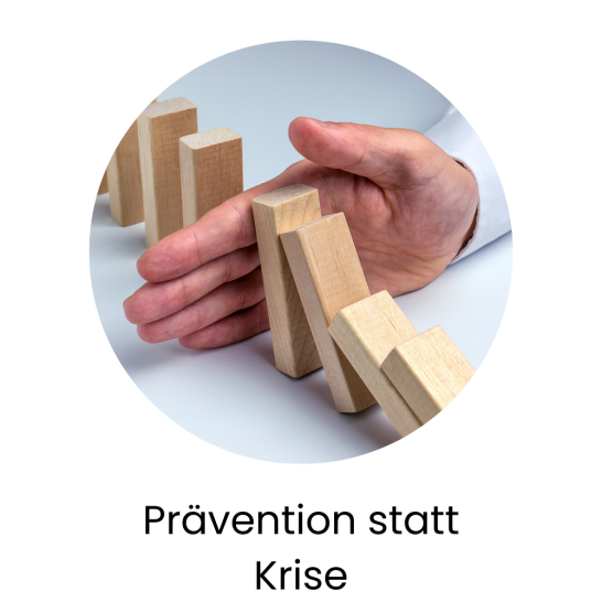 Eine Hand verhindert das Umfallen von Holzteilen, Motto: "Prävention statt Krise".
